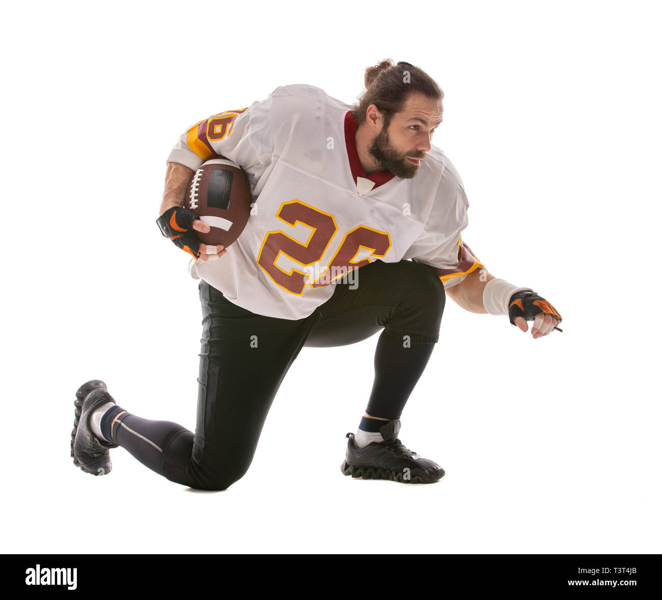 Bearded American football player sitting on his knee Stock Photo Alamy