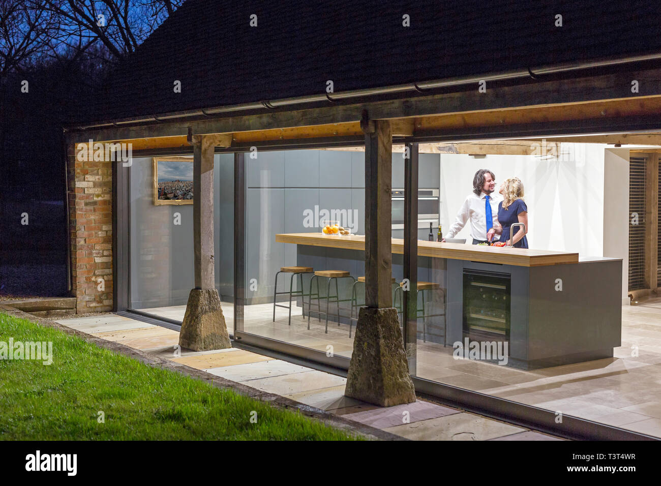 Caucasian Couple In Kitchen Of Converted Barn Home Stock Photo