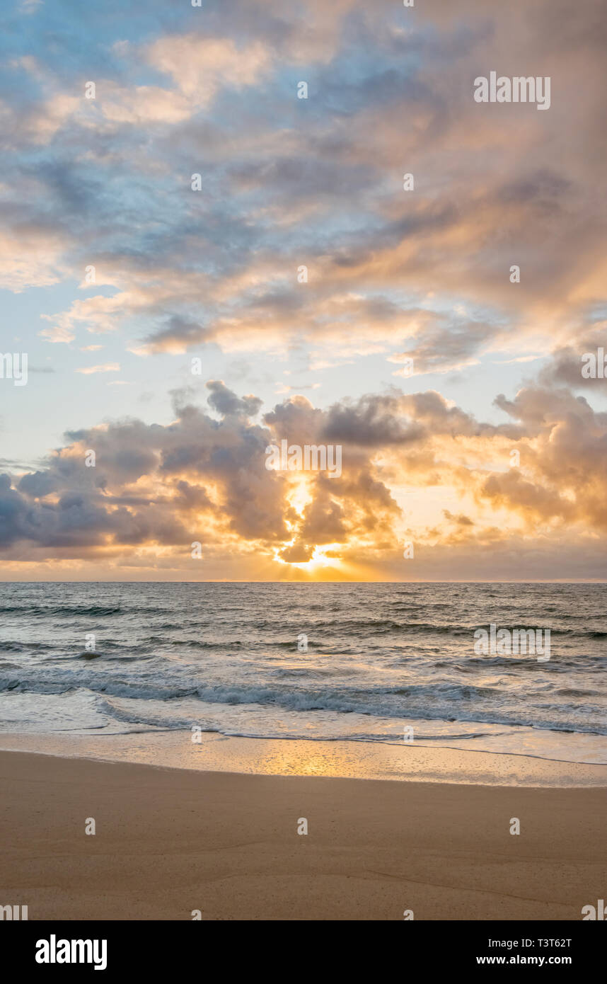 Sunrise over ocean on beach Stock Photo