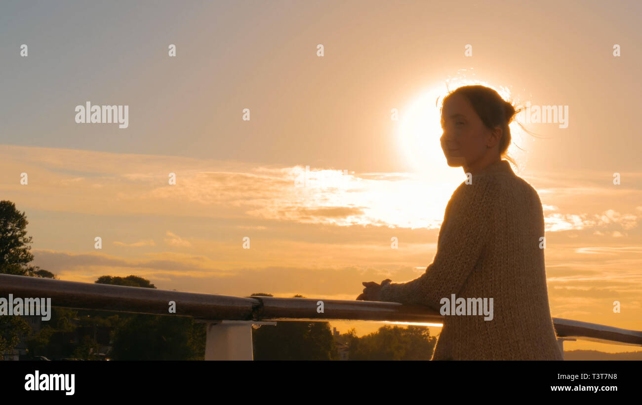 Woman admiring sunset from deck hi-res stock photography and images - Alamy