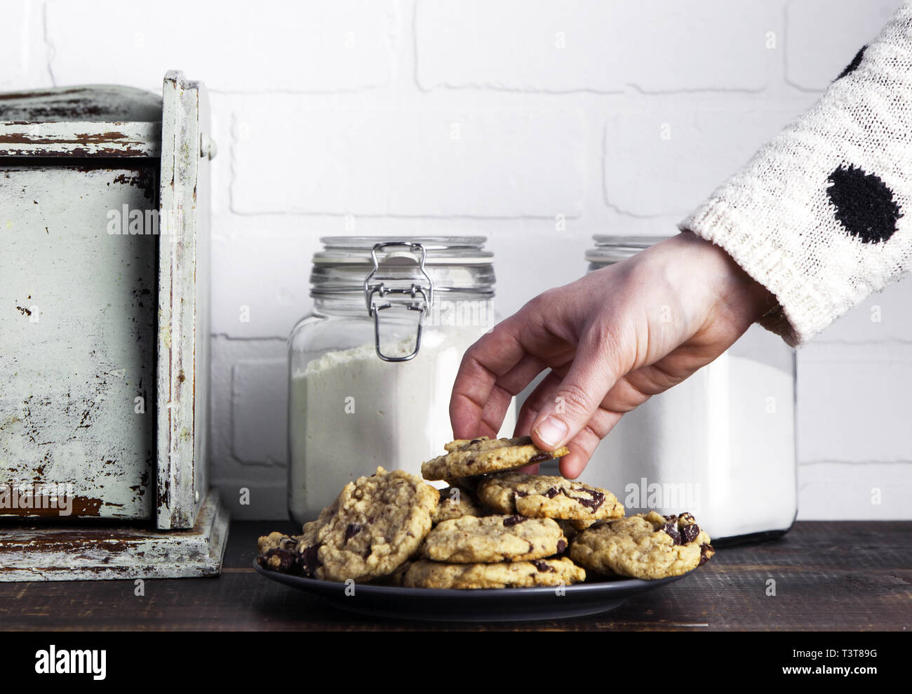 Hand taking cookie from plate Stock Photo