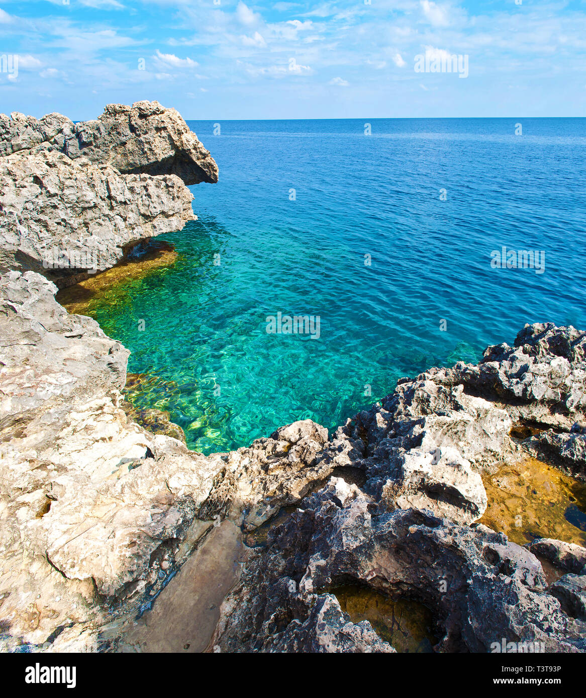 View of a bay near Cape Greco, Cyprus. Rock coastline near deep green transparent turquoise water. Amazing landscape. Warm day in fall Stock Photo