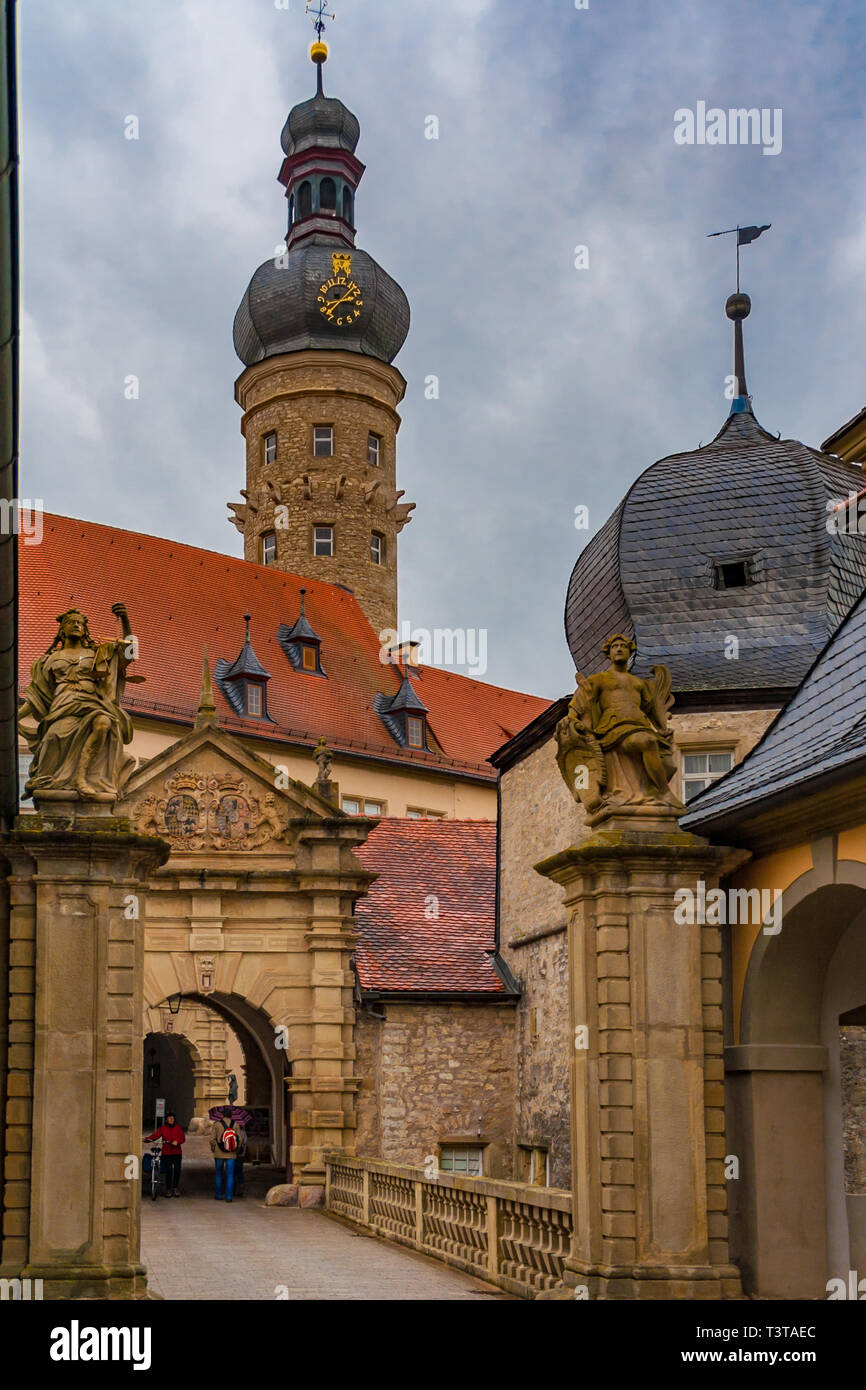 A portrait photo of the baroque entrance to Weikersheim Palace with the medieval keep on a cloudy rainy day in Weikersheim, Baden-Württemberg, Germany. Stock Photo