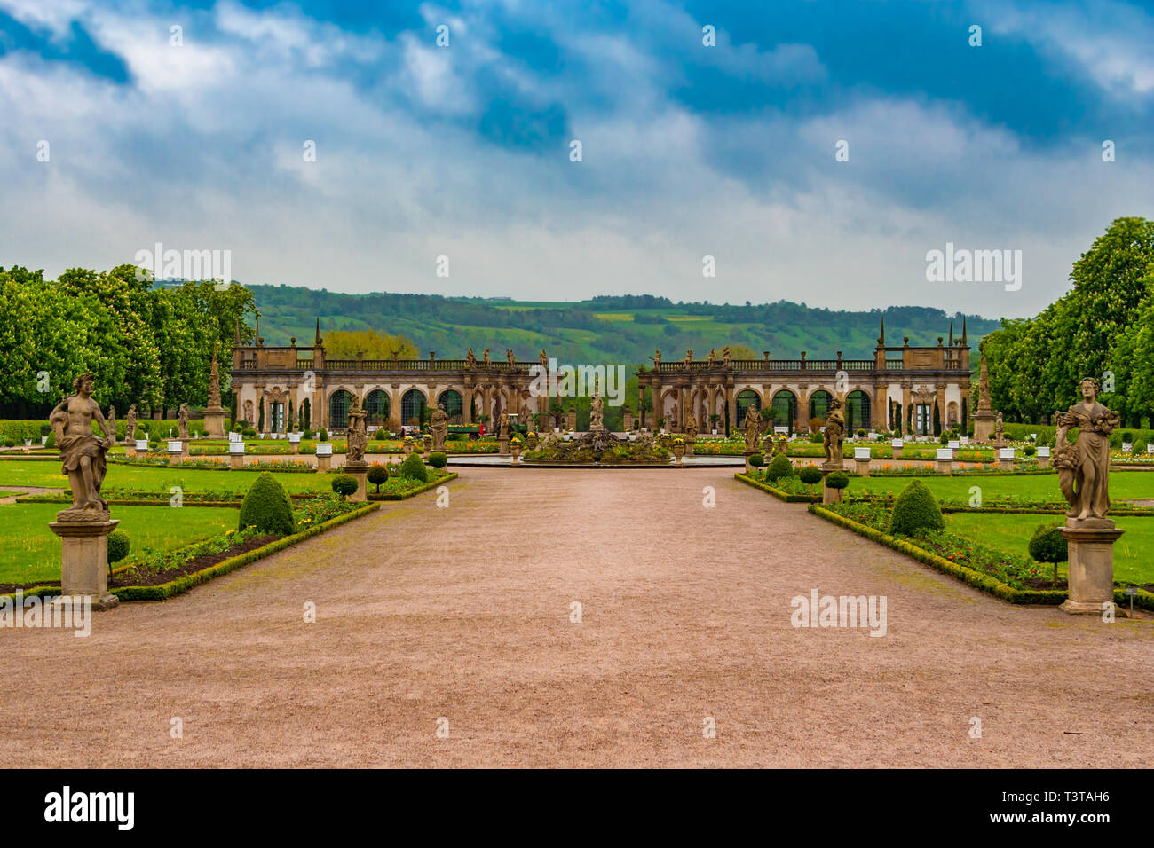 The lovely walkway to the Baroque garden of Weikersheim Palace, framed by two statues, is leading to the beautiful Hercules Fountain in the middle and... Stock Photo
