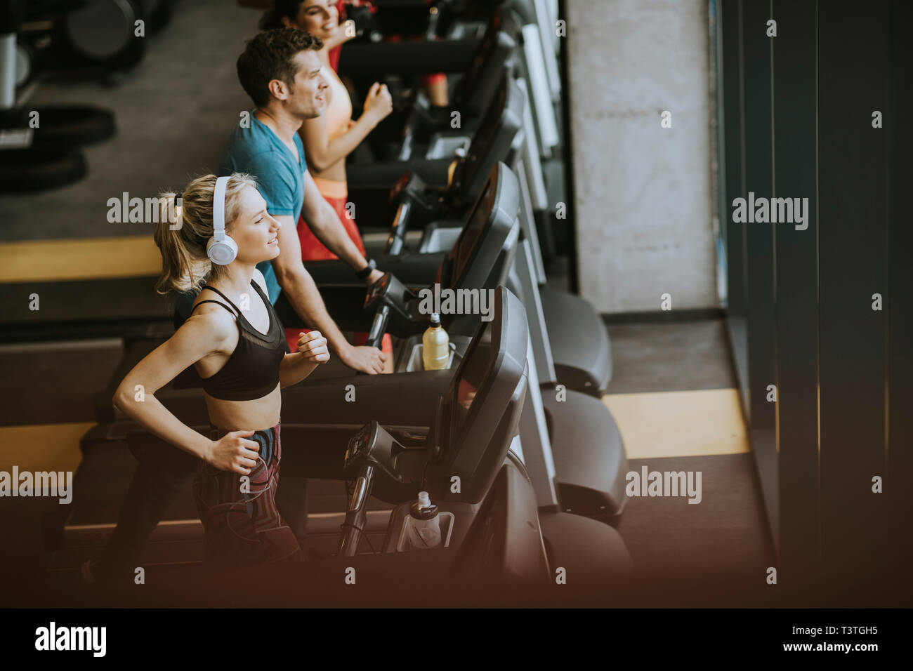 Top view at group of young people running on treadmills in modern sport gym Stock Photo