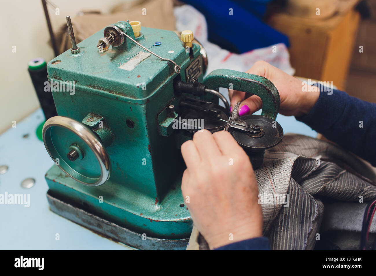 Female hands doing maintenance work on a domestic sewing machine Stock
