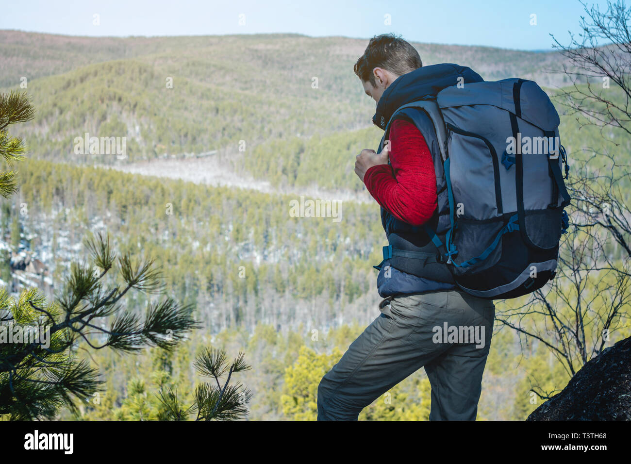 Man tourist hiker with a large backpack stands on a rock cliff and looks at  the sprawling green valley. The concept of freedom in travel Stock Photo -  Alamy