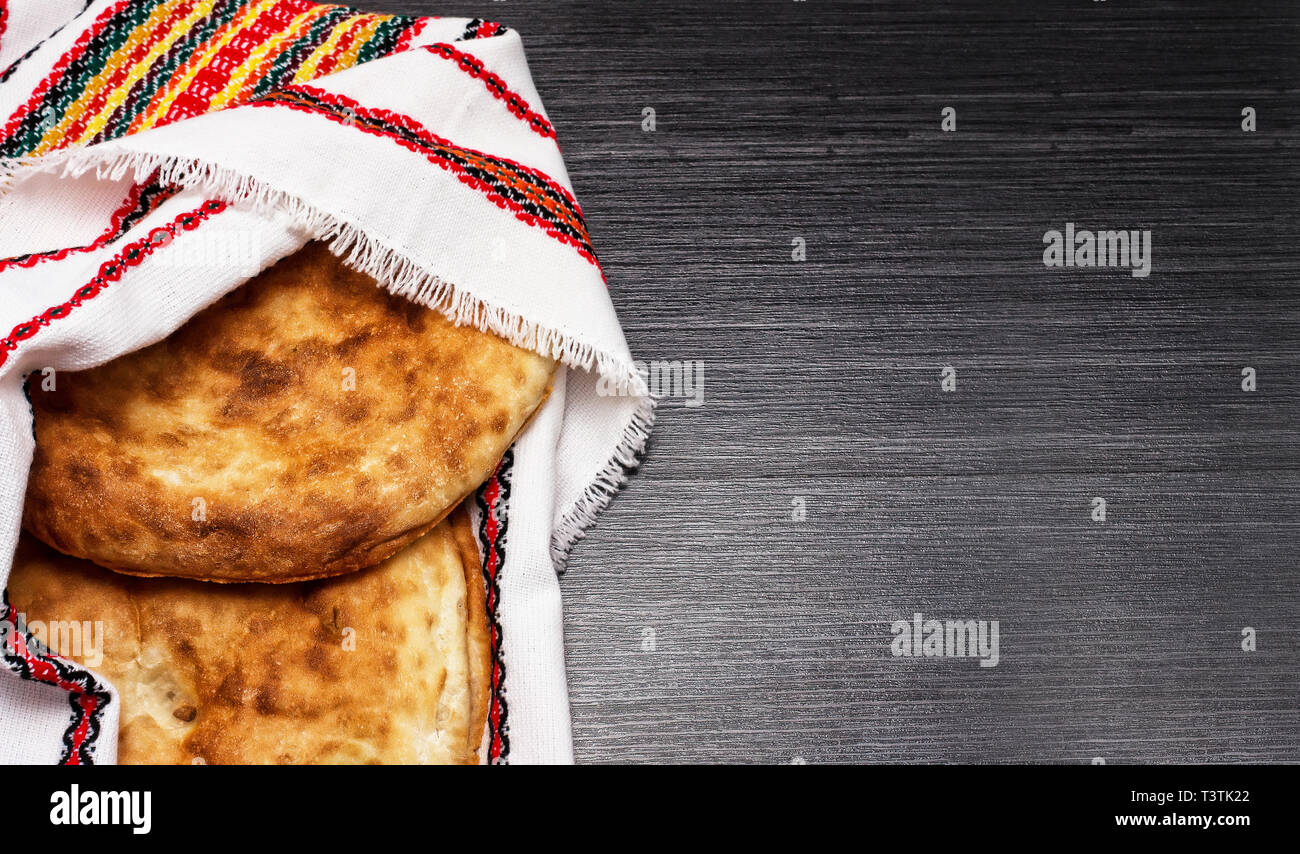 Two pita bread lying on multicolor napkin. Wooden texture. Rustic food