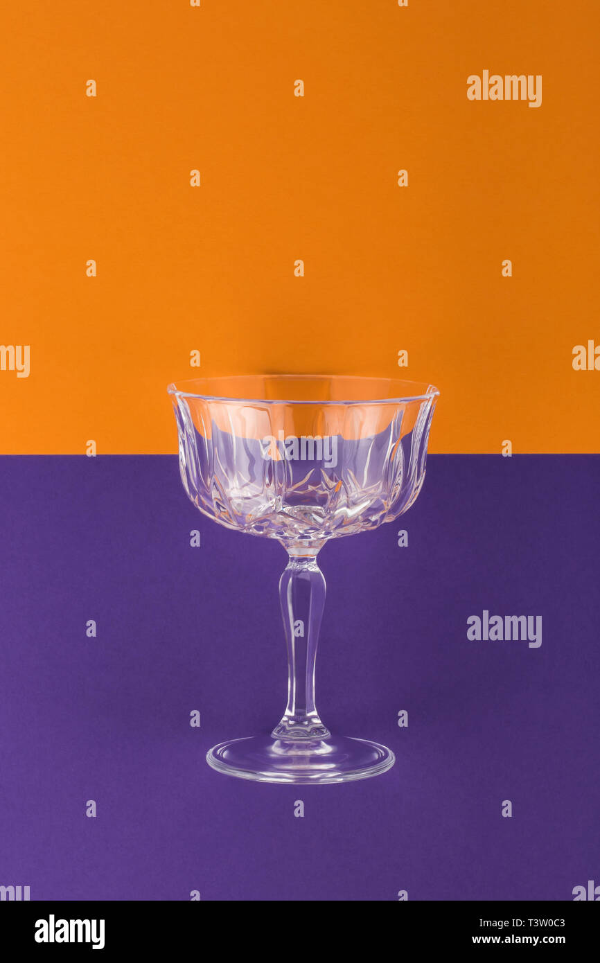 Champagne glass on purple and orange background Stock Photo
