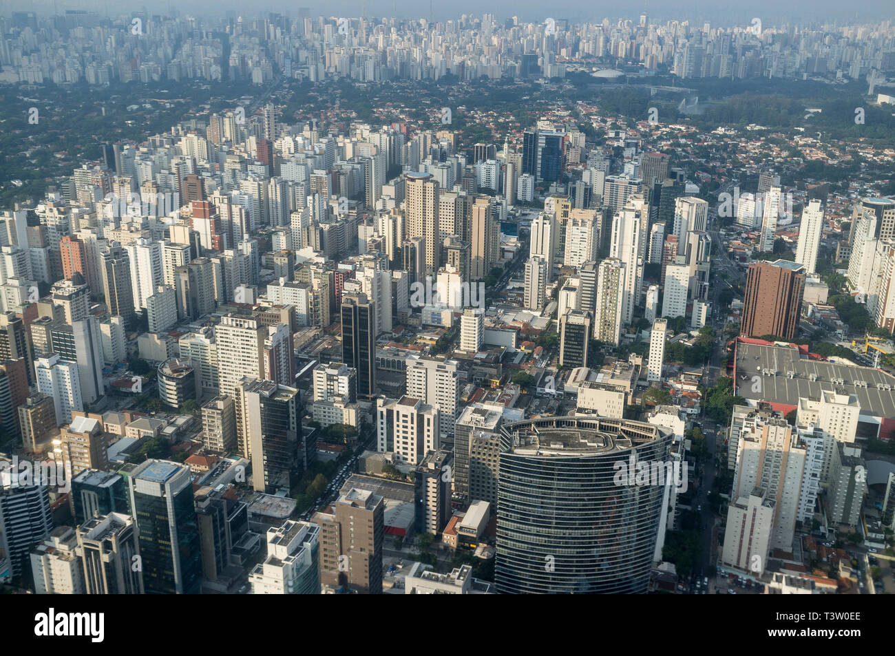 Aerial view of the city of Sao Paulo, Brazil - dense populated neighborhood - Itaim Bibi district, Credit Suisse building in foreground -  mixed with green upper-class area in background (Jardins district ) and Ibirapuera Park at right. Stock Photo