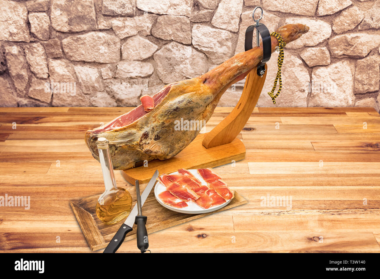 Spanish Jamon Serrano on wooden tabla jamonera with knife, apple, glass and  bottle of red wine. Home cooking, food photo concept Stock Photo - Alamy