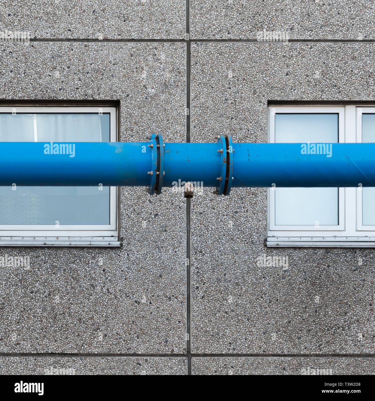 The blue water pipe in front of the windows of the prefabricated house Stock Photo