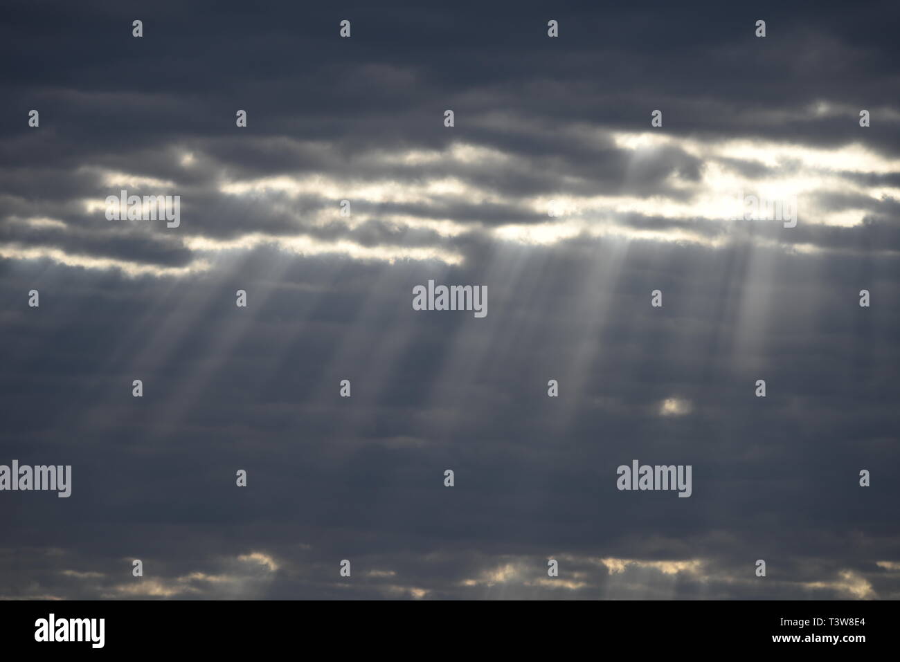 Heaven Beams shine through dark clouds Stock Photo
