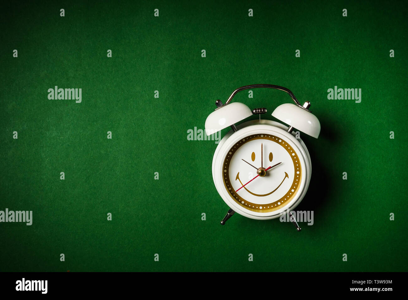 small white clock placed on a green background Stock Photo - Alamy