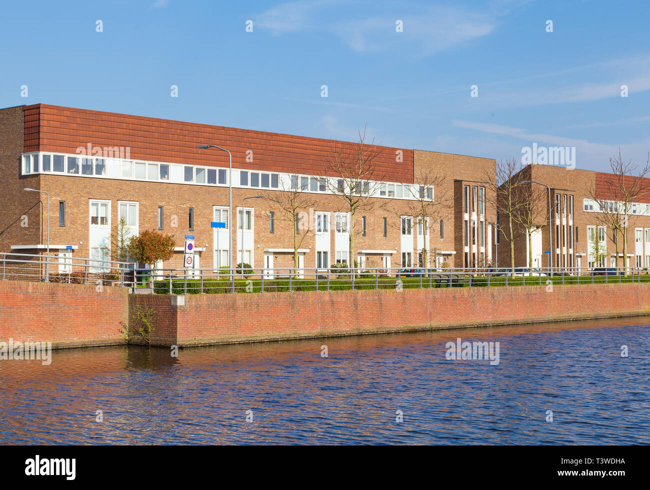Row of modern brick houses along water in a family friendly suburban neighborhood in Veenendaal
