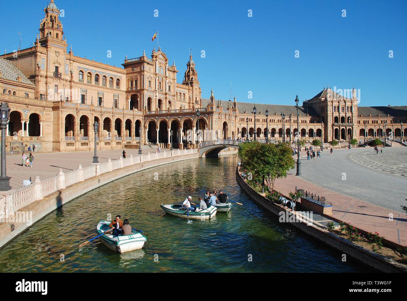 People row boats on the moat of the historic Plaza de Espana in Seville, Spain on April 3, 2019. It was built for the 1929 Ibero-American Exposition. Stock Photo