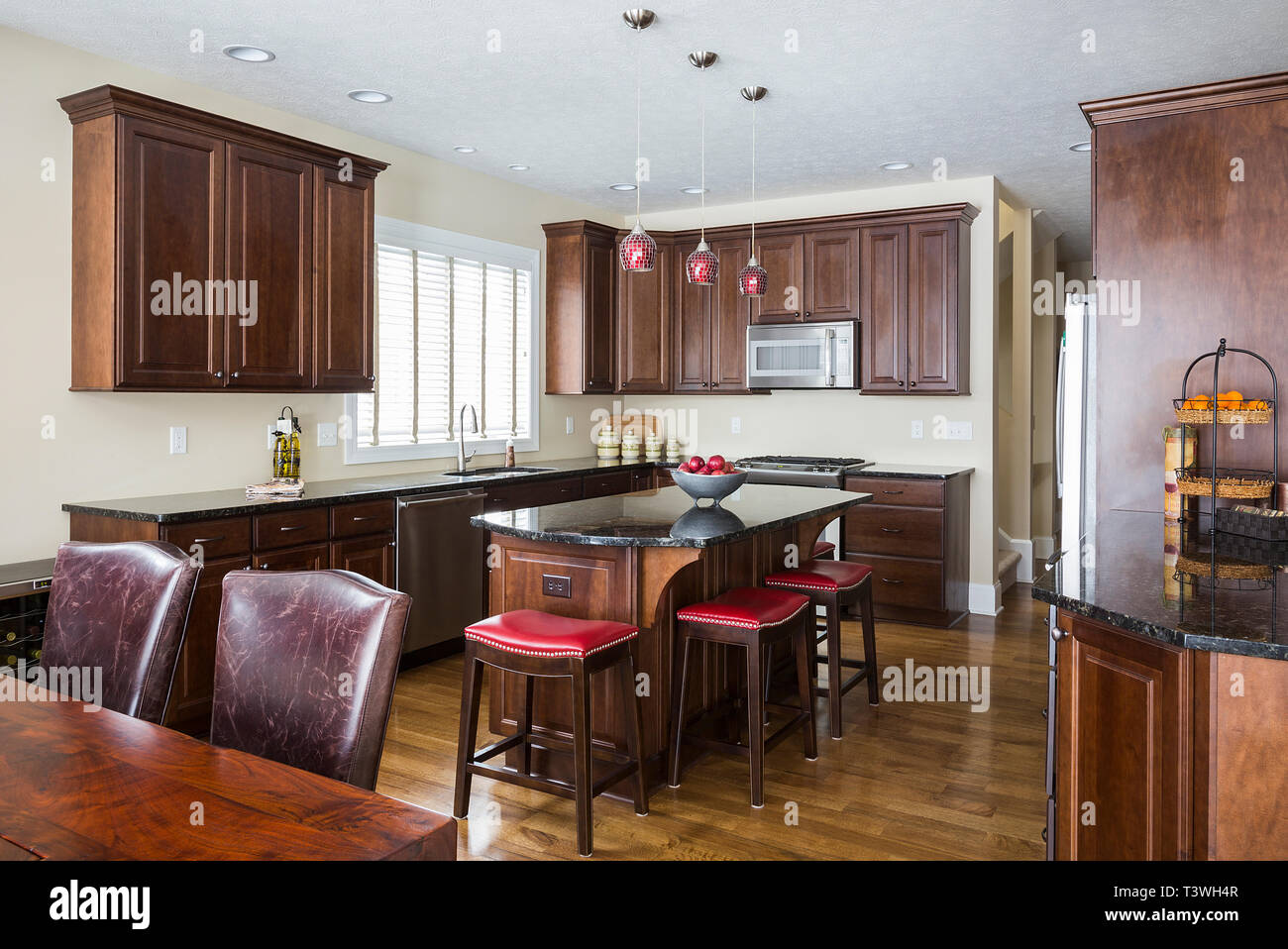 Kitchen island, table and cabinets in modern kitchen Stock Photo - Alamy
