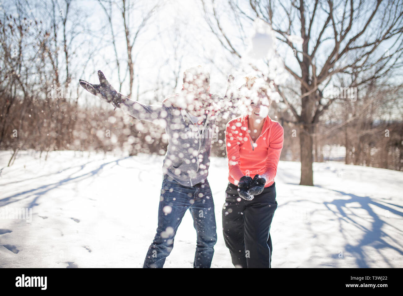 Caucasian couple throwing snowballs Stock Photo - Alamy