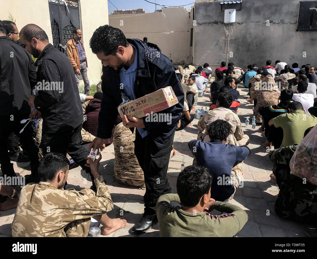 Zawia, Libya. 11th Apr, 2019. Libyan fighters loyal to the self-styled  Libyan National Army (LNA), led by Libyan strongman Khalifa Haftar, queue  on the ground at a detention centre while receiving food,