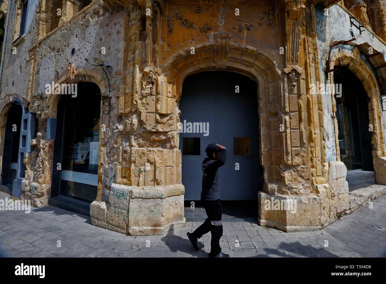 (190412) -- BEIRUT, April 12, 2019 (Xinhua) -- A man passes by the destroyed Barakat building, which now is 'Beit Beirut' museum in Beirut, Lebanon on April 2, 2019. April 13 marks the 44th anniversary of the outbreak of Lebanon's civil war (1975-1990). But after 29 years of the end of the war, some buildings in Beirut still bear witness to this war and remain the same despite the growth of its surroundings. (Xinhua/Bilal Jawich) Stock Photo