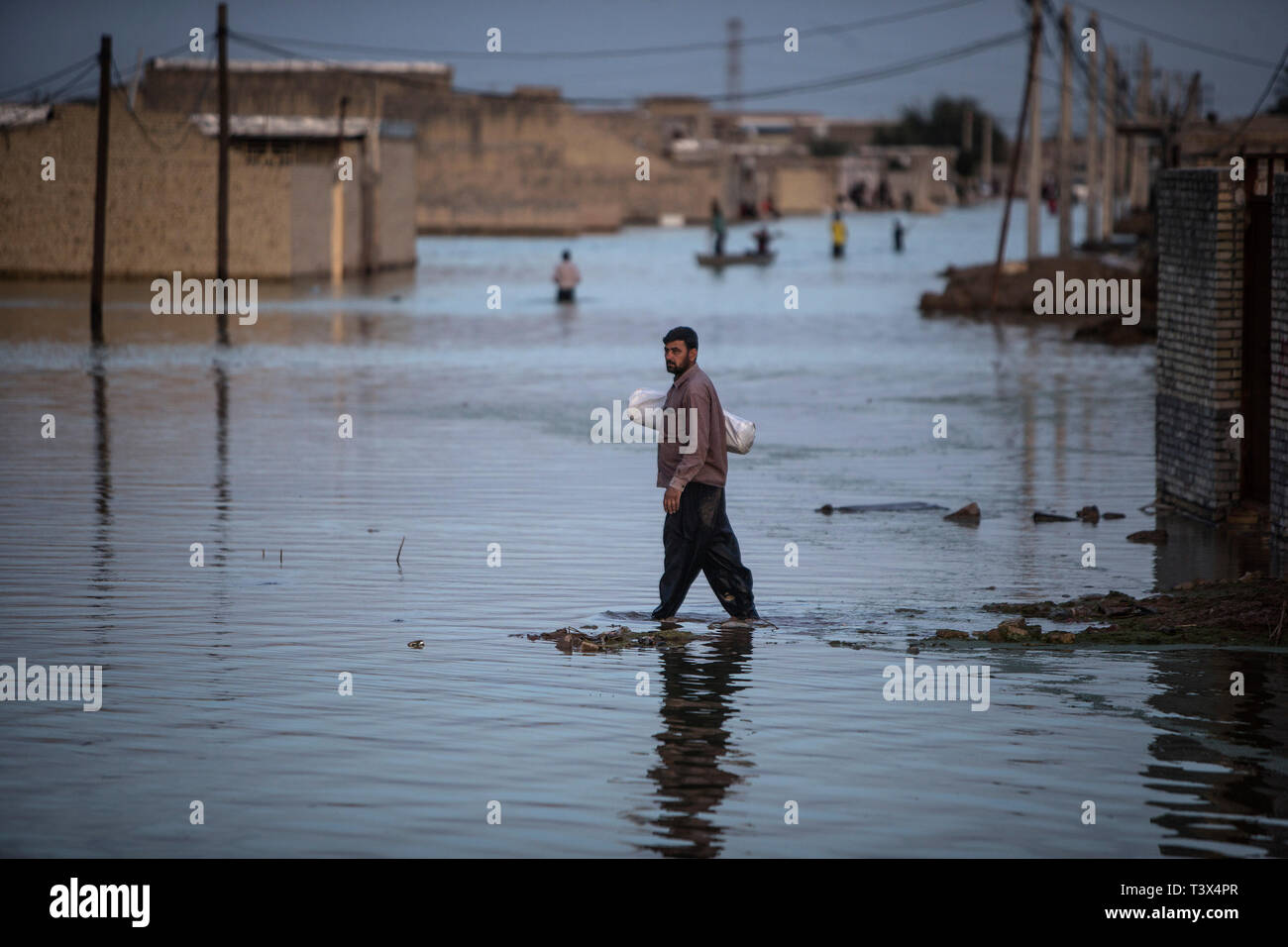 (190412) -- AHVAZ, April 12, 2019 (Xinhua) -- People wade through flood waters just outside Ahvaz city, capital of Khuzestan province, Iran, April 11, 2019. (Xinhua/Ahmad Halabisaz) Stock Photo