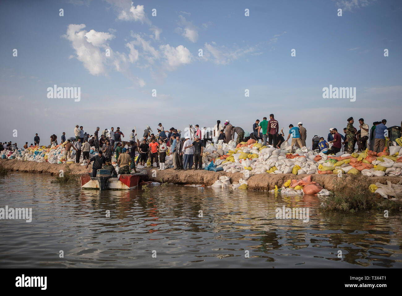 (190412) -- AHVAZ, April 12, 2019 (Xinhua) -- People build handmade dams to block the flood waters just outside Ahvaz city, capital of Khuzestan province, Iran, April 11, 2019. (Xinhua/Ahmad Halabisaz) Stock Photo