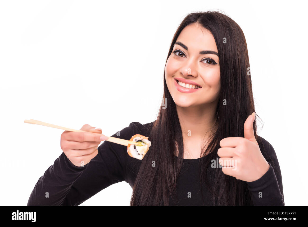 Cheerful Young Asian Woman Eating Sushi With Chopsticks Isolated Over