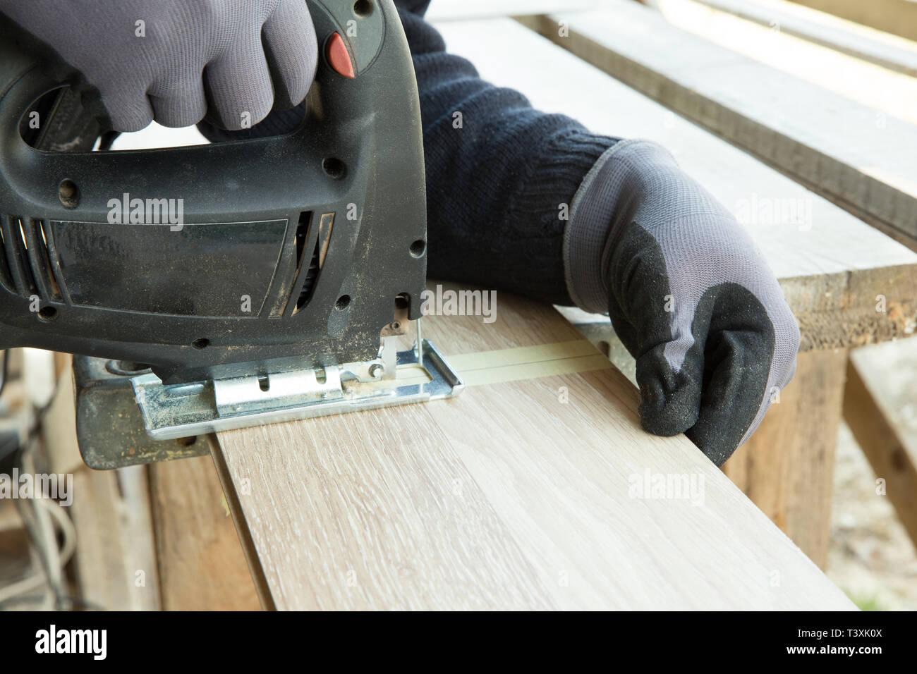 Man laying laminate flooring in construction concept. Construction