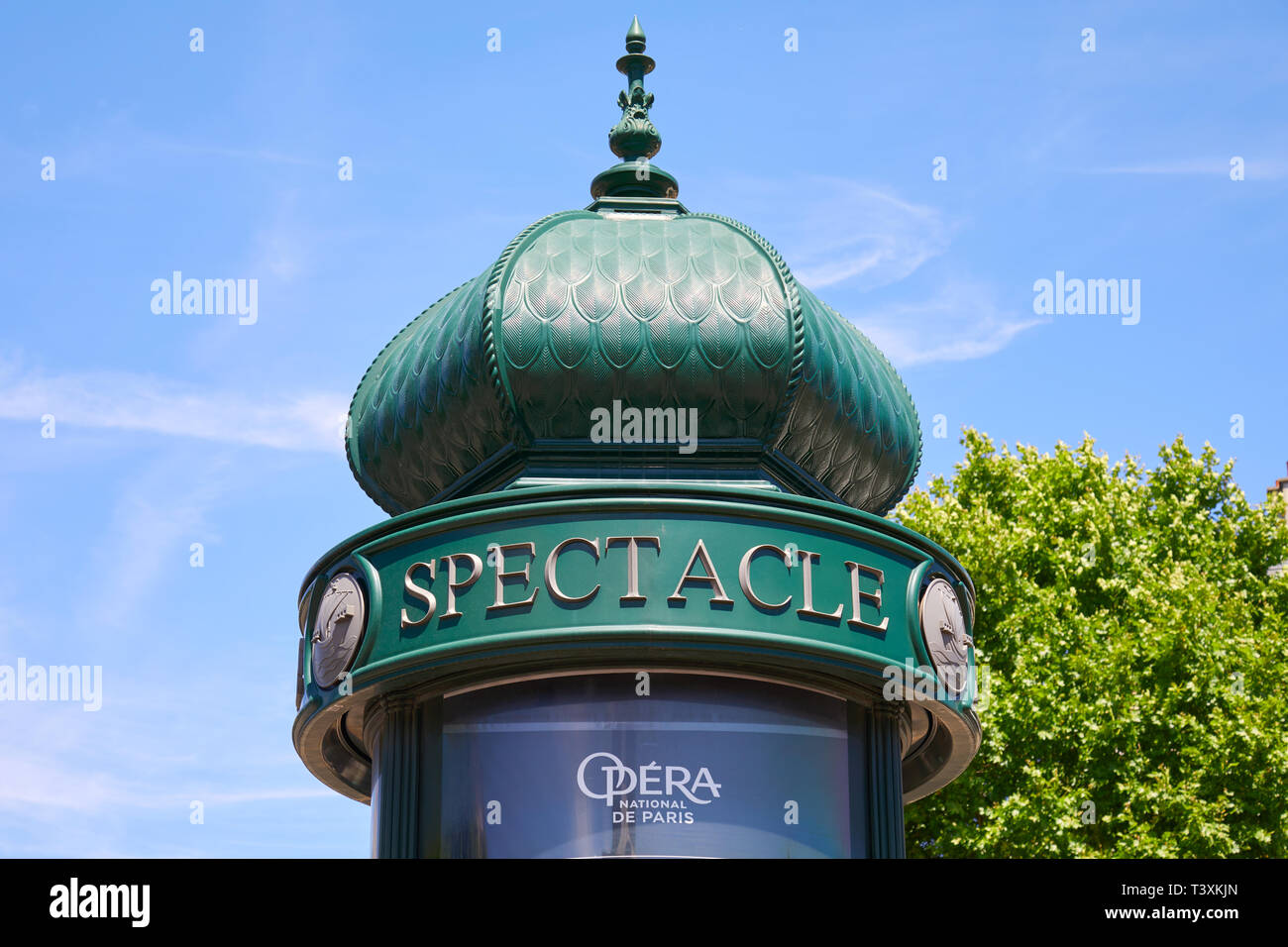PARIS, FRANCE - JULY 21, 2017: Typical green advertising column or Morris column in Paris in a sunny summer day, blue sky in France Stock Photo