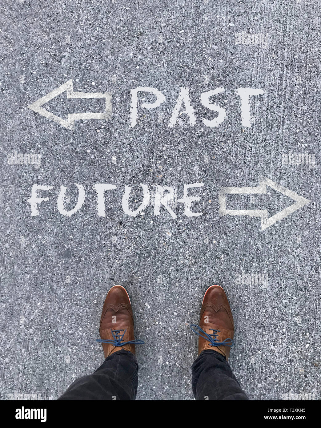Man standing in front of two arrows and the words "Past" and "Future" Stock Photo