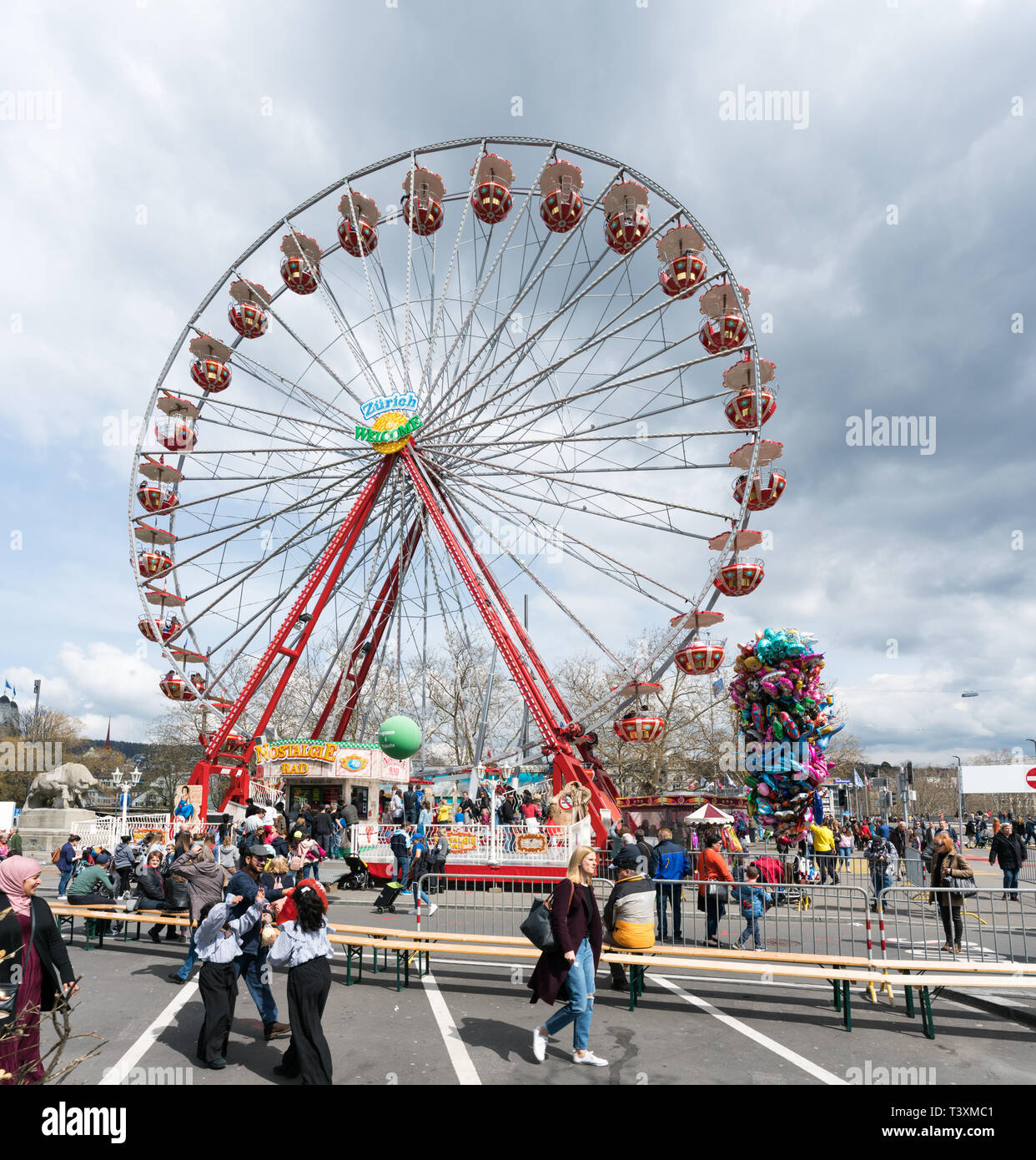 Zurich, ZH / Switzerland - April 8, 2019: people gathering at the Sechselauten spring festival in Zurich and enjoying the amusement park rides and att Stock Photo
