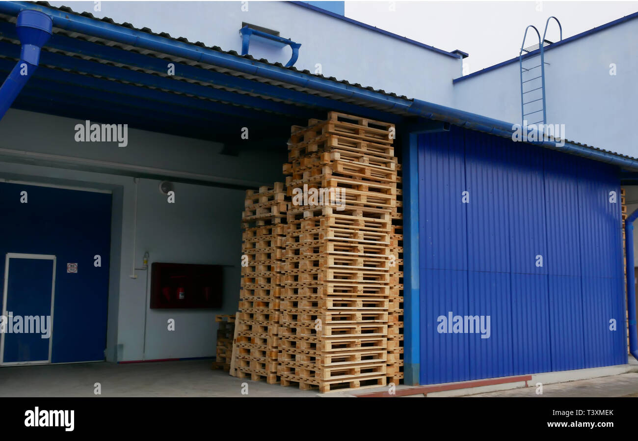 Pallets in a stack in a production warehouse Stock Photo - Alamy