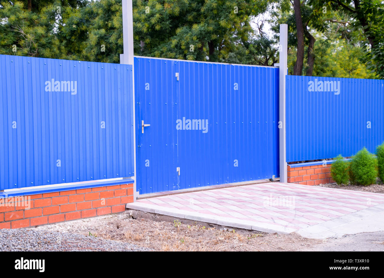 Fence and gate from sheets of blue corrugated metal Stock Photo - Alamy