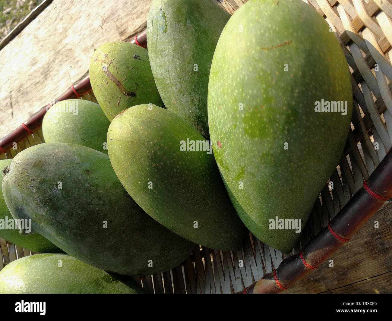 green mango on basket and old wooden desk ,group of mangoes fruit, sour