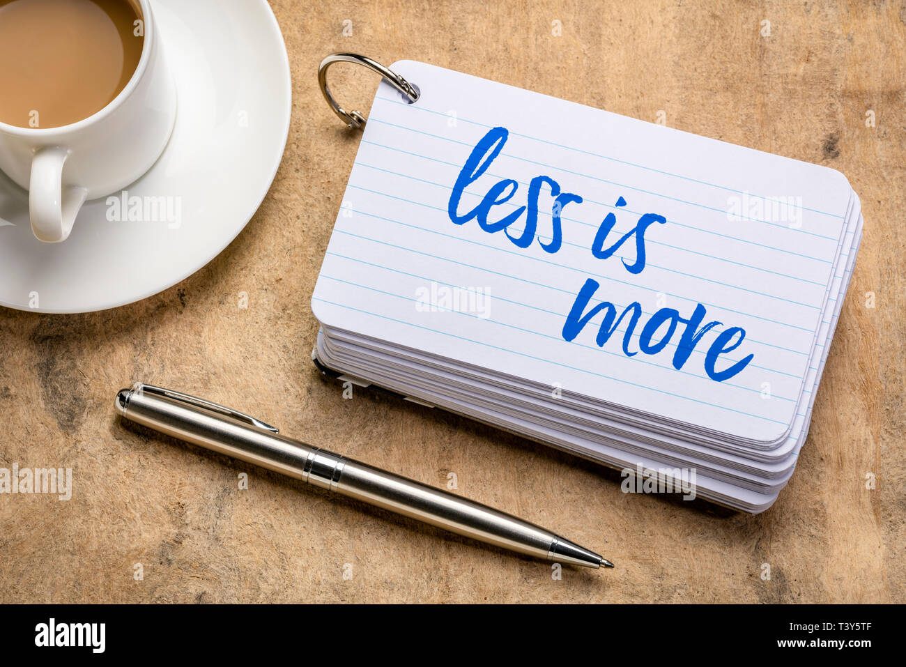 less is more - handwriting on a stack of index cards with a cup of ...