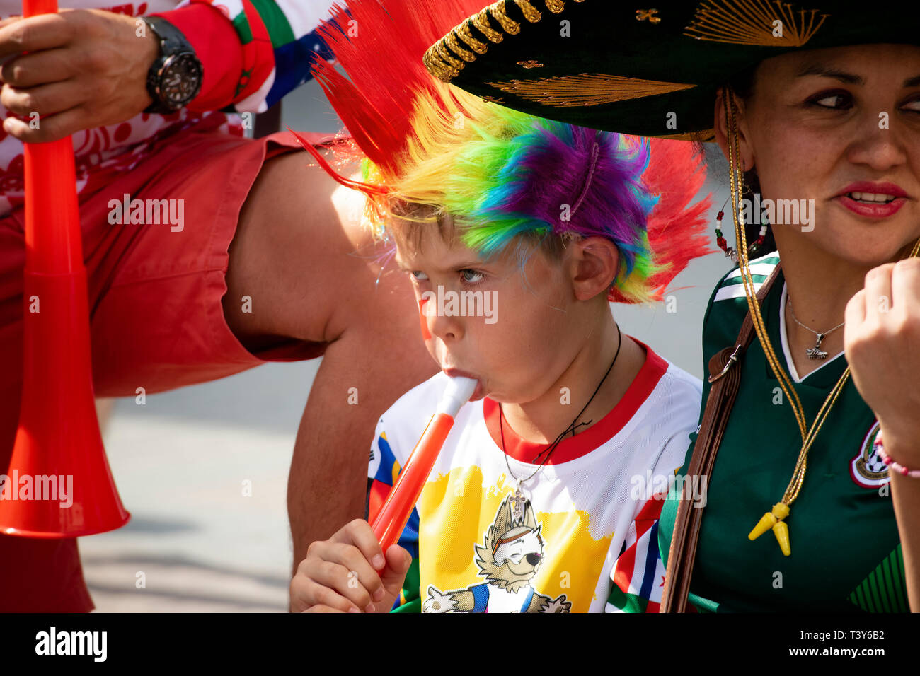 Boy in Swedish football shirt wearing multi-coloured punk-style wig and blowing vuvuzela - FIFA World Cup Russia 2018 Mexico v Sweden, Ekaterinburg Stock Photo