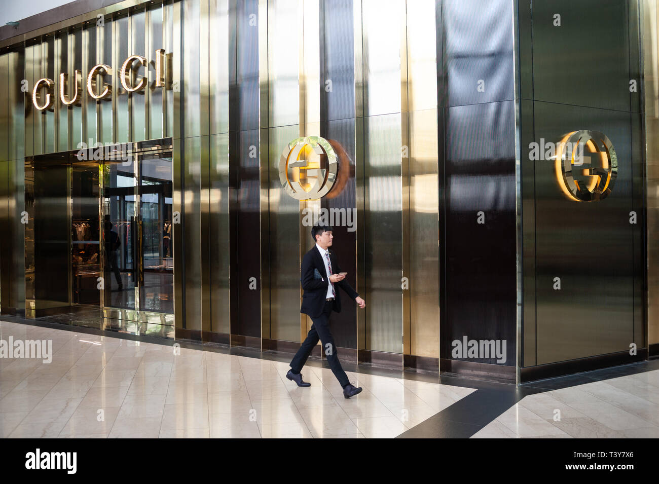 04.04.2018, Singapore, Republic of Singapore, Asia - A man is walking by a retail store of the Gucci fashion brand in 'The Shoppes' shopping mall. Stock Photo