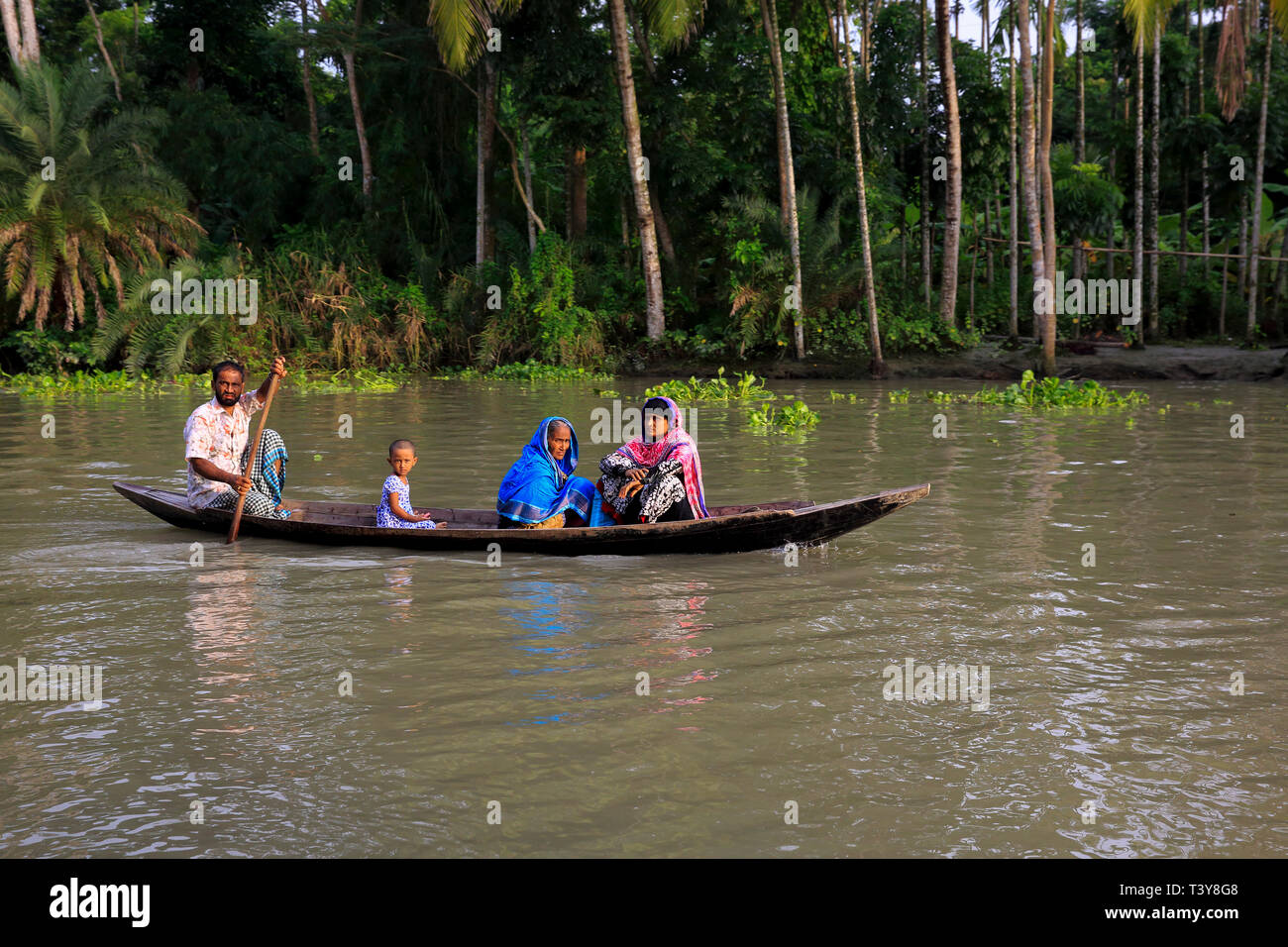 A rural family travelling on a small boat at Najirpur in Pirojpur, Bangladesh. Stock Photo
