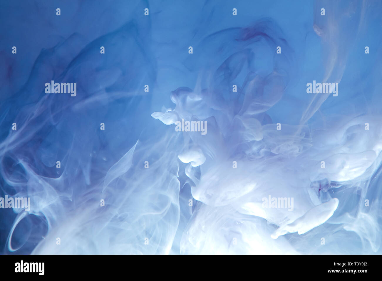 Bright blue drops in water on a white background. Colored abstract drop ...