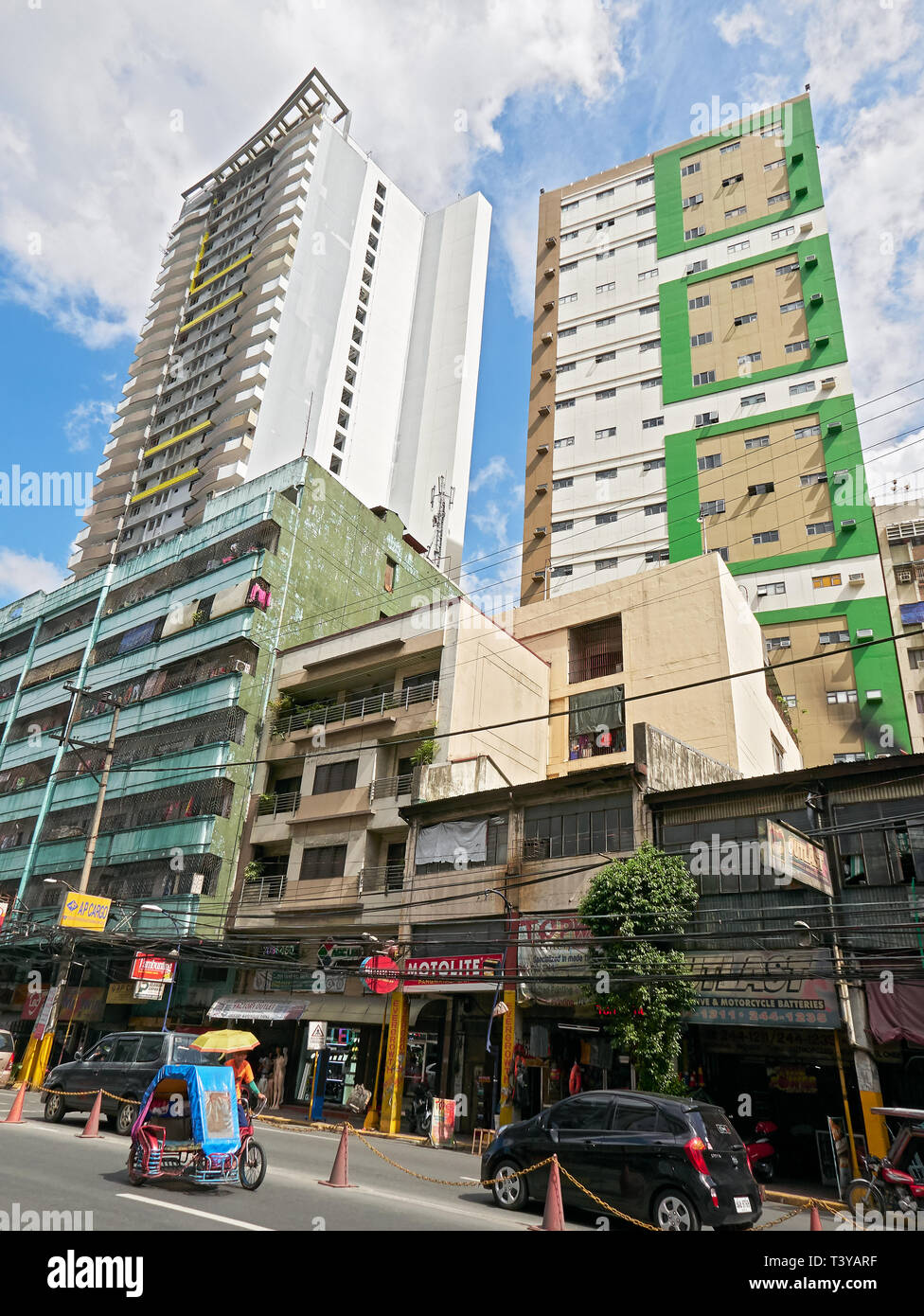 Binondo, Manila, Philippines: Low-angle view of two high-rise residential buildings and Chinese owned stores and street in front Stock Photo