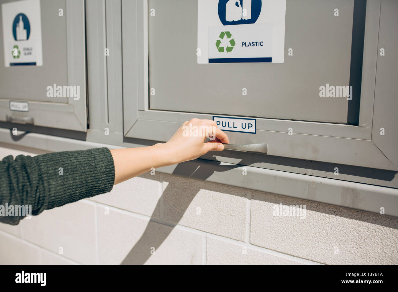 A person opens or closes a modern waste bin for separate collection of waste. Stock Photo