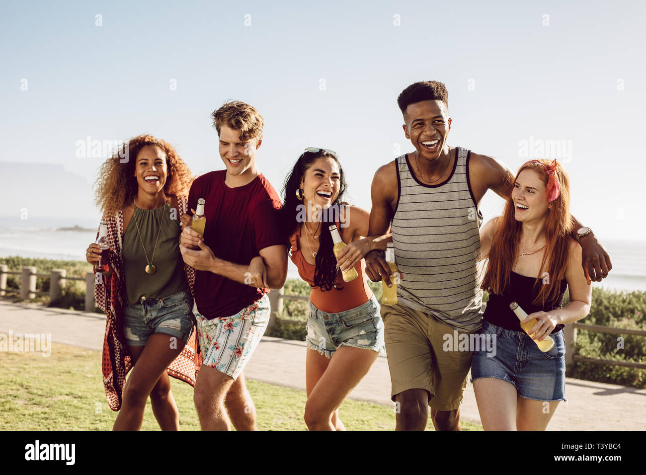 Multiethnic group of men and women walking together with locking arms