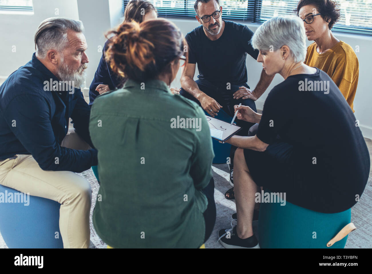 Multi-ethnic group of people sitting together having a meeting. business people having a group discussion on new working strategy. Stock Photo
