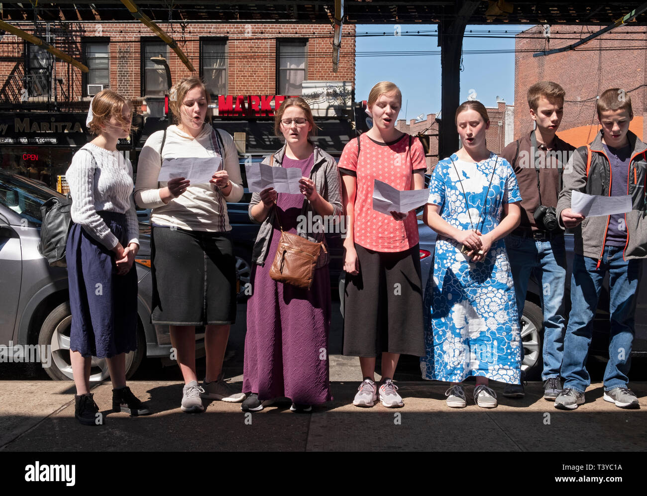 Teenage Mennonite missionaries from Pa. singing hymns in Spanish in Corona Queens trying to reach out to the overwhelmingly Spanish speaking residents Stock Photo