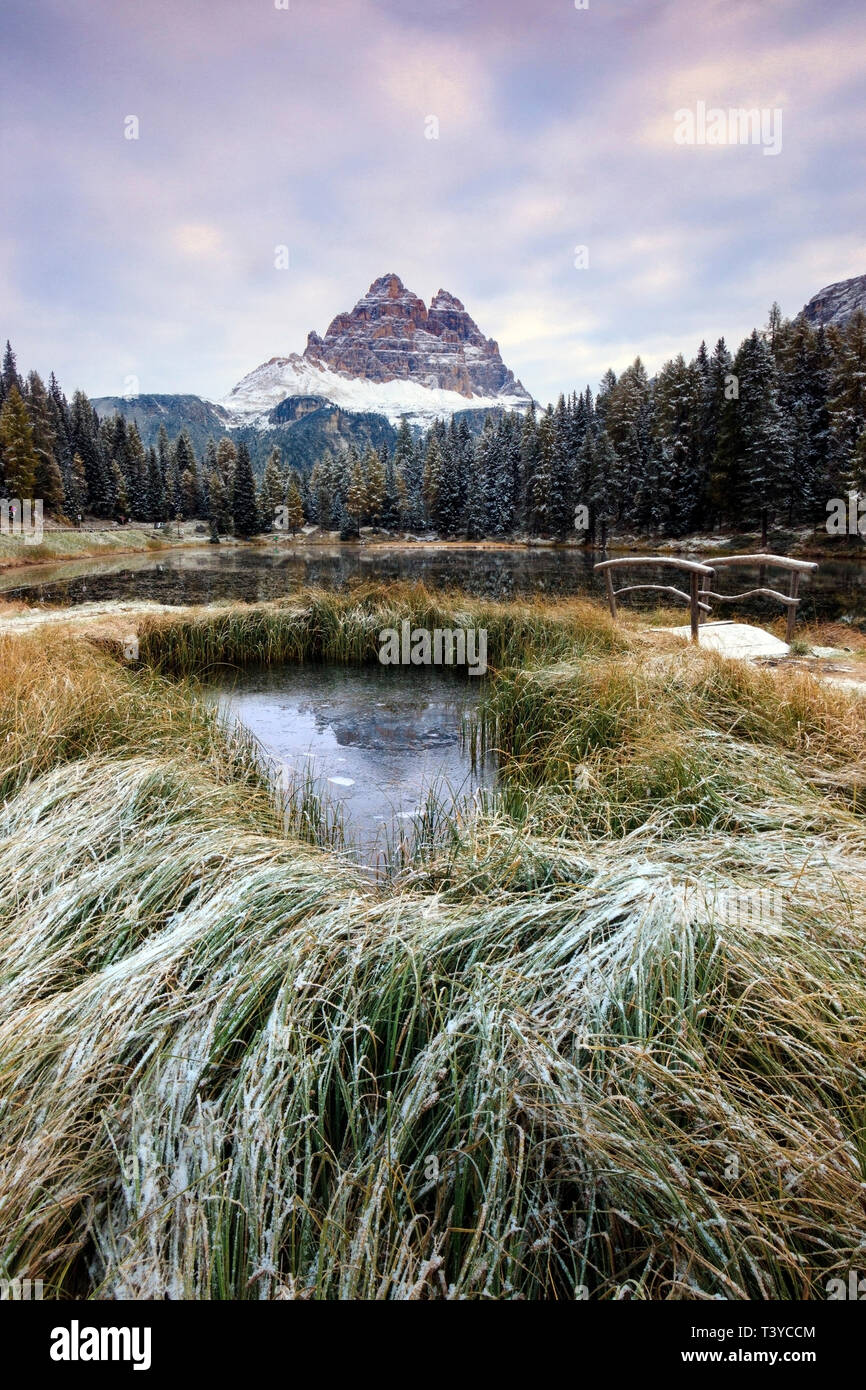 A view at sunrise of Lake Antorno, a small pond in the Dolomites of Ampezzo, surrounded by some of the best looking mountains of the world, such as Tr Stock Photo