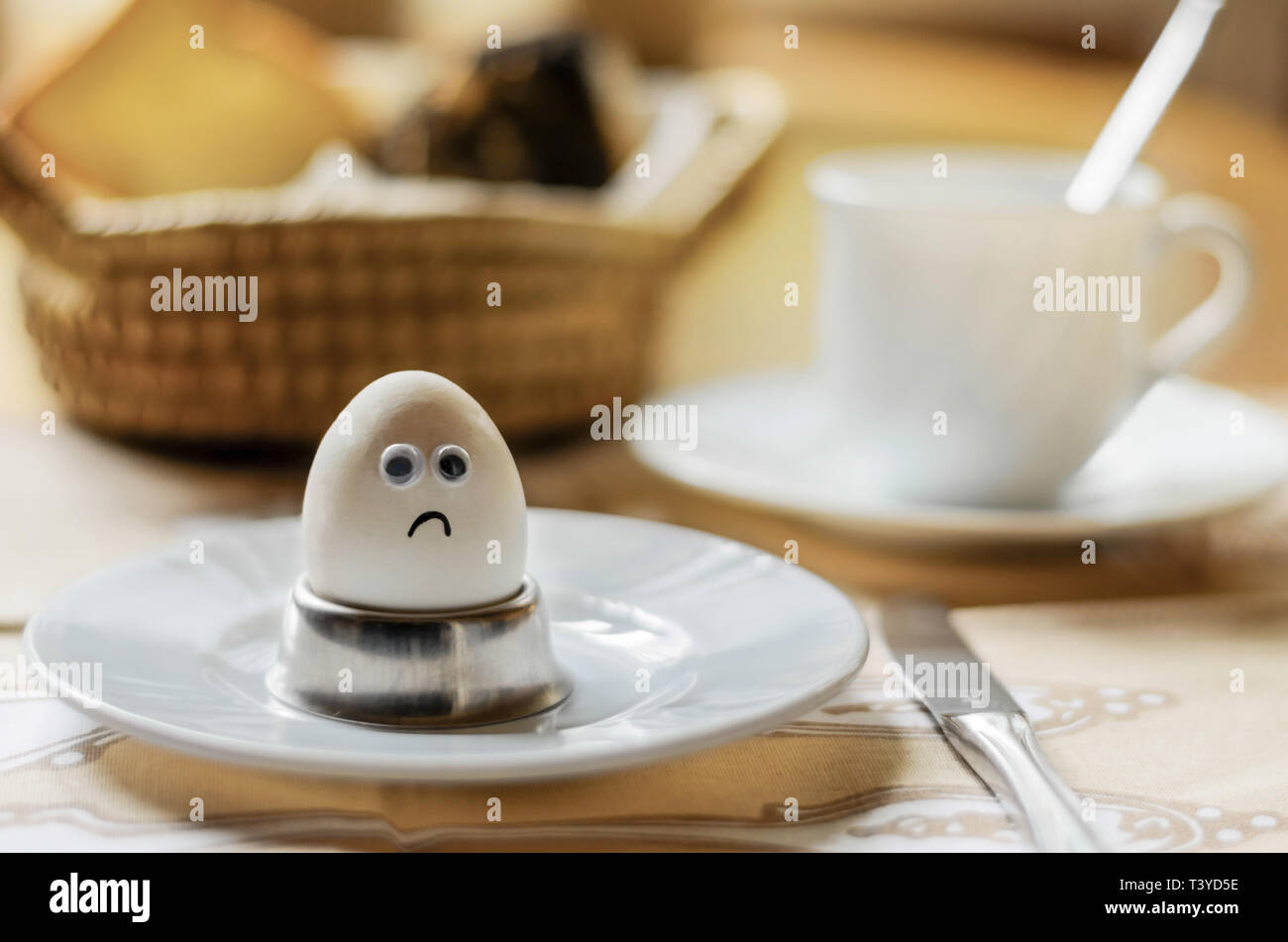 sad egg on breakfast table Stock Photo