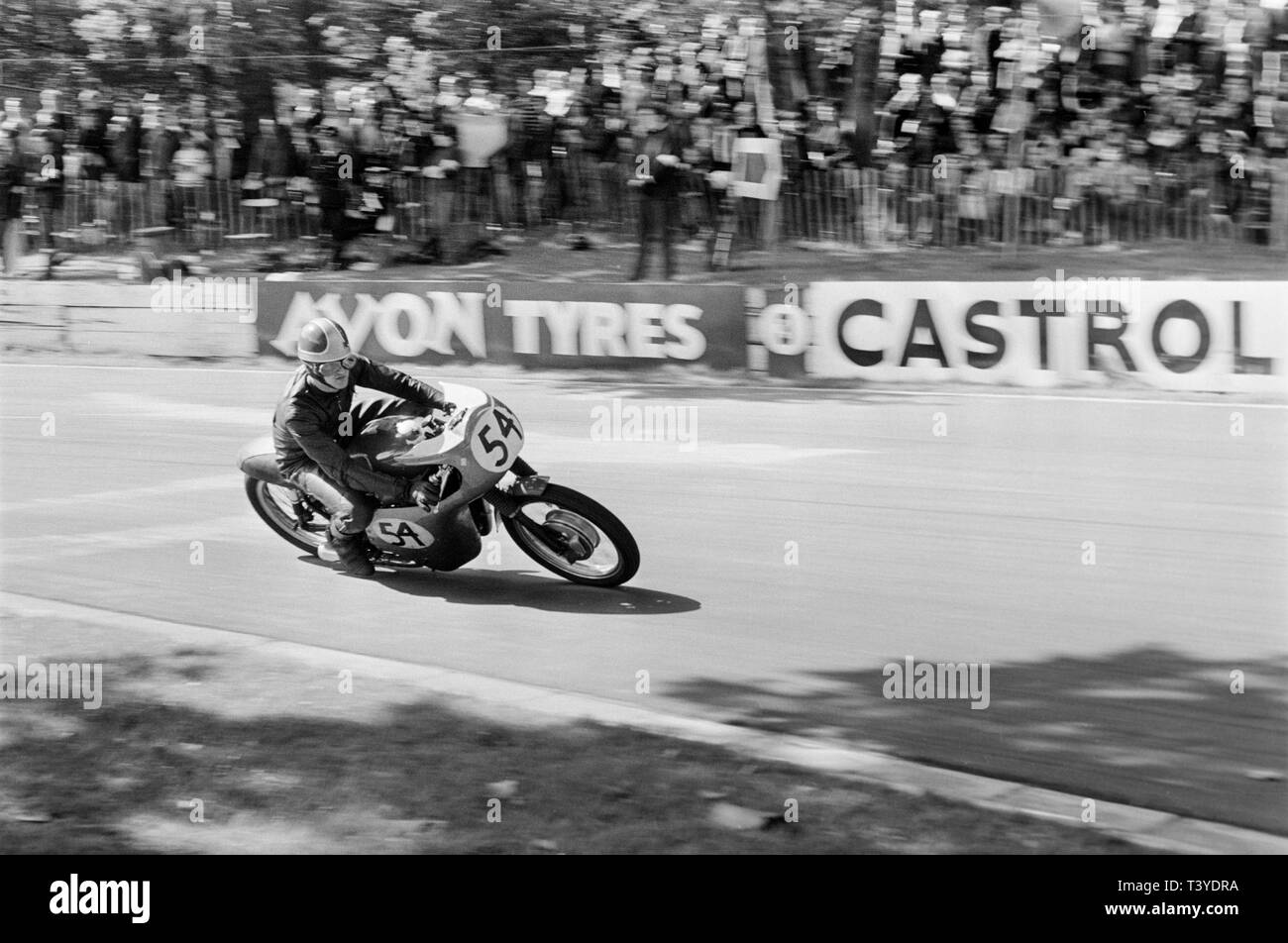 Motorcycle racing at Crystal Palace near London in 1968. A motorcycle racer, number 54, approaching in to a bend on the track. The Crystal Palace racing circuit was closed in 1972. Stock Photo