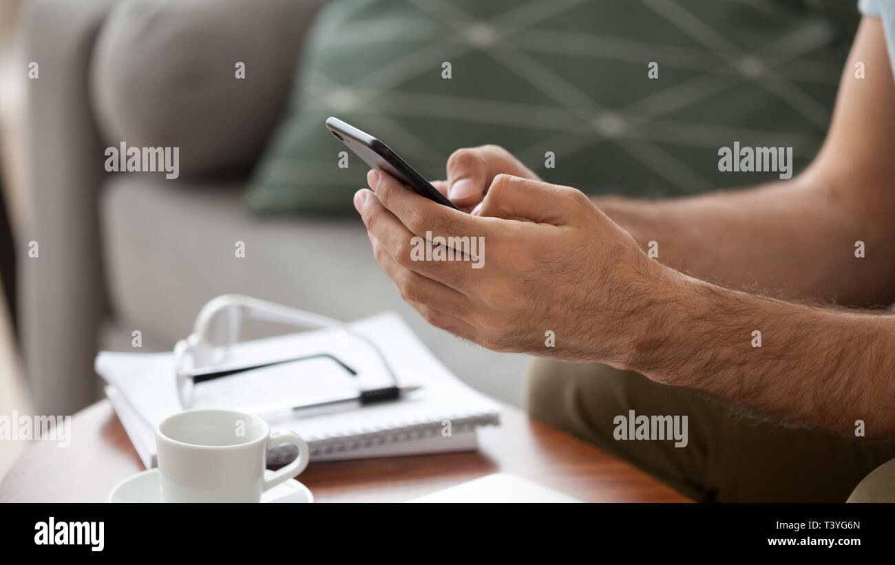 Close up man using, holding phone in hands, typing message Stock Photo