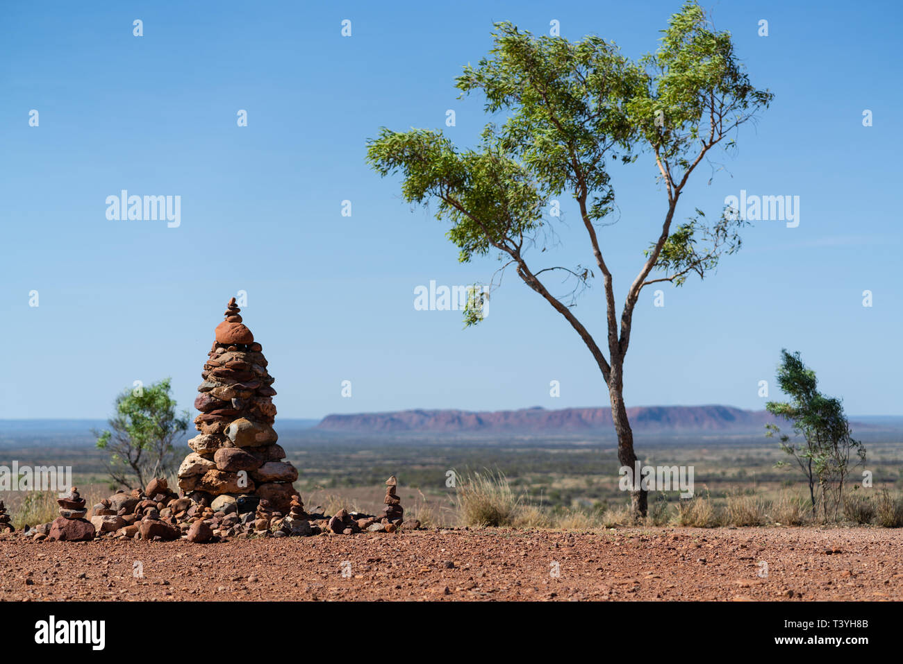 Cairn and gum tree with outback landscape in background in NT outback Australia Stock Photo