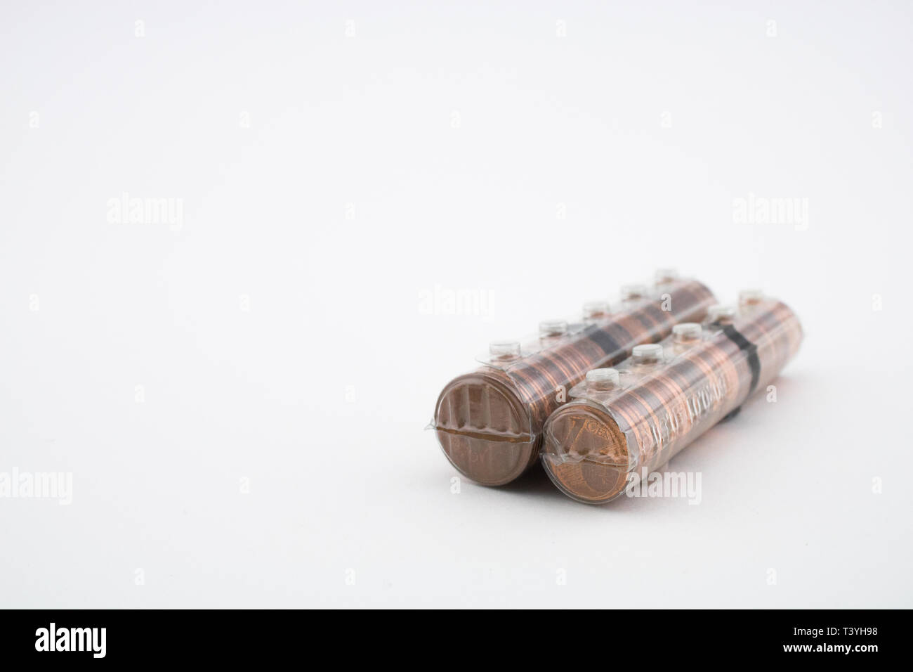 Rolls with coins of five euro cents and one euro cents isolated on white background. Rolls with euros. Savings of coins to enter the bank. Stock Photo